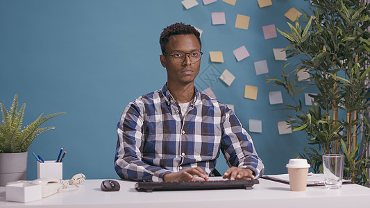 在办公桌使用计算机的非洲美洲男子肖像图片