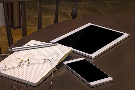 办公桌手机平板电脑眼镜笔记本和带复制空间的笔 在一张木桌上的小工具教育学校药片展示学习技术电话商业屏幕木头图片