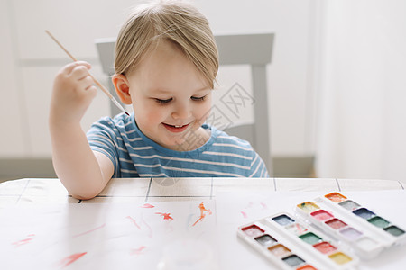 儿童在白桌上用水彩颜料绘画和绘画 开发儿童的创造潜能艺术童年幼儿园桌子插图画笔享受闲暇家庭乐趣图片