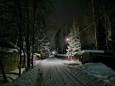 冬季夜晚俄罗斯村庄 一条有雪和光的公路 从房屋窗户上走出来房子月亮森林日志天空旅游建筑乡村小屋夜空图片