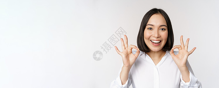 特写亚洲女孩的头像 表现出好的 好的手势和满意的微笑 推荐 高兴 赞美和恭维 白色背景企业家工作室售货员老板手臂女性人士商务女士图片