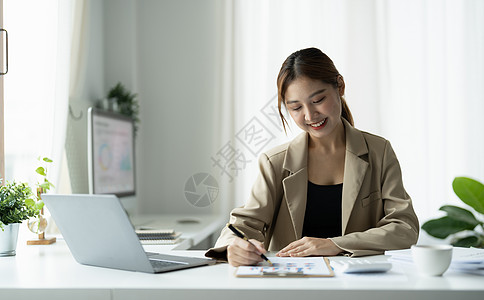 商业妇女利用笔记本电脑在办公室木制办公桌 税务 会计和财务概念上做数学融资女士支付商务营销报告人士桌子银行业工作预算图片