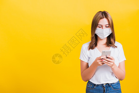 妇女戴面罩 阅读智能手机新闻更新消息预防女性流感电话药品卫生感染防护女士面具图片