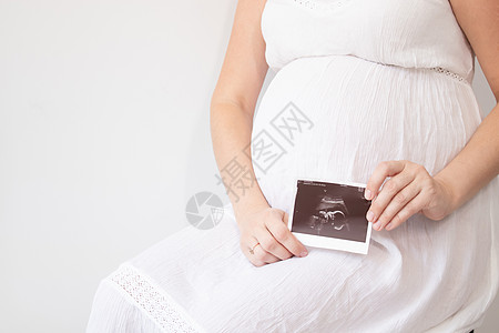 孕妇有怀孕超声波照片 享受孕期的快乐时光 母亲怀着可爱的大肚子 笑声孩子扫描父母医疗肚子母性卫生保健女士检查图片