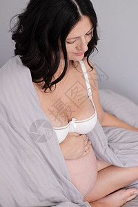 快乐漂亮的女人享受怀孕 母亲是期待父母 可爱的大肚子 怀孕的黑发在明亮的房间里一部分身体孩子客厅生活方式女士母性肚子头发休息图片