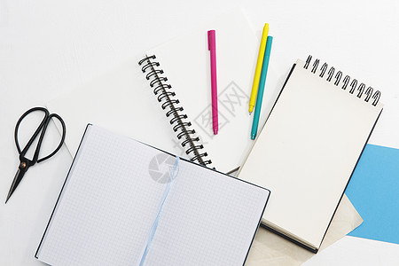 许多弹簧笔记本 多色纸 蓝色 红色 绿色 金色 钢笔和剪刀 办公理念 放置文本毡笔架子学校钱包日记画板学习夹子风格装饰图片