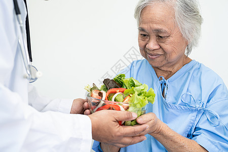 亚洲年长或年长的老妇人病人在医院的床上坐着饿着肚子 满怀希望和快乐地吃着早餐蔬菜健康食品医生办公室护士孩子从业者手术男性托盘诊所图片