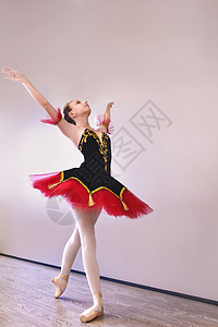 一位年轻的芭蕾舞演员优雅地站在演播室里 脚趾上穿着足尖鞋 芭蕾舞学生在表演前在演播室练习古典舞女士有氧运动短裙身体女性运动成人舞图片