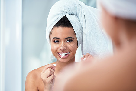 一张更干净的笑容 一个女人戴着毛巾蒙住头戴牙缝时用牙套着牙齿的照片图片