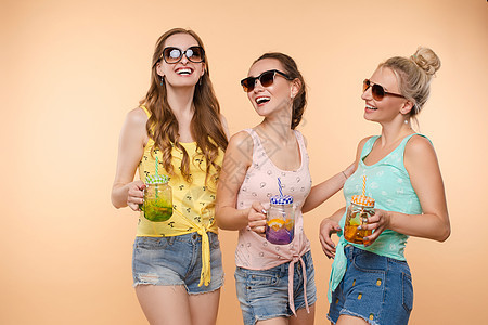 美好的生活 三位穿着夏装 拿着鸡尾酒的漂亮苗条女人在笑 在一起玩得很开心 工作室 孤立的背景 康乐理念朋友们友谊情绪幸福派对化妆图片