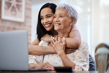这是生活中的那些小时刻 一位老年妇女和她的女儿在家里使用笔记本电脑的镜头图片