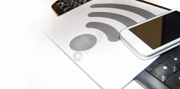 计算机键盘和移动电话 无线互联网 复制空间附近的一张纸上的无线-Fi符号图片