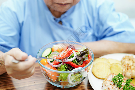 亚洲年长或年长的老妇人病人在医院的床上坐着饿着肚子 满怀希望和快乐地吃着早餐蔬菜健康食品护士退休医生手术诊所裁剪微笑男性女孩房间图片