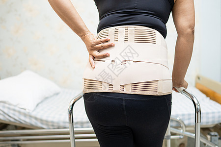穿背止痛带的亚洲女病人 用助行器换整形腰椎身体绷带肌肉药品腰部腰背扭伤矫正胸衣姿势图片