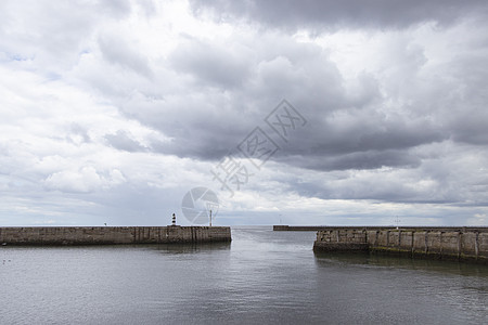 灯塔光码头上带有云彩和海墙的有标志性条纹海滨灯塔潮汐遗产墙壁英语地标石头海景支撑港口房子背景