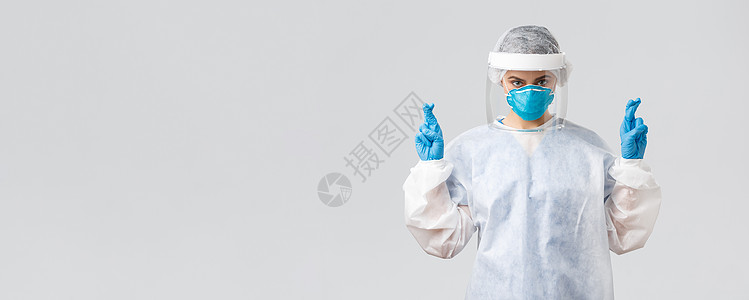 Covid19 预防病毒 医护人员的概念 个人防护装备的医生或护士 带呼吸器和面罩的医疗服 希望对抗冠状病毒 交叉手指疾病科学工图片
