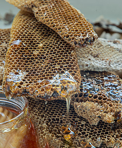 与重叠的新鲜蜂窝特写了蜂蜜滴落香气营养品味道草药美食饮食琥珀色金子玻璃罐健康饮食图片