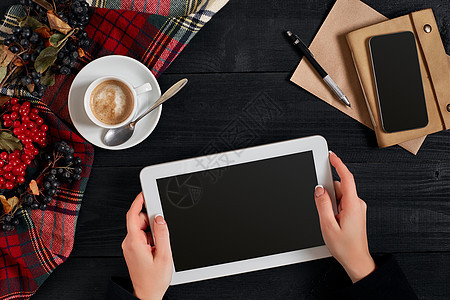 妇女手握平板板 黑屏在桌子上方 一杯咖啡和智能咖啡屏幕互联网工具办公室女士药片技术电脑手指手机图片