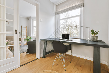 进入一个小办公室 桌上有一个笔记本电脑桌面家具内阁木头椅子木地板地面房间桌子财产图片