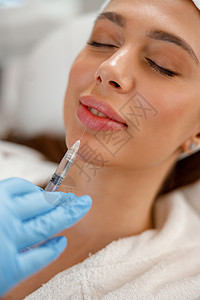 在美容院的嘴唇上 缝合年轻女性被注射恢复活力的近身图片