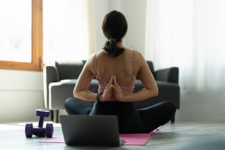 年轻的瑜伽女子练习瑜伽 坐在 Vajrasana 姿势中 背后合十礼 穿着粉红色运动服锻炼图片