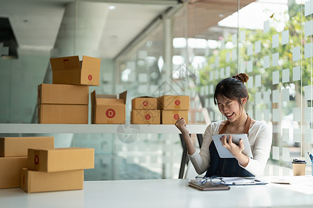 创业小企业自由职业者 肖像快乐的年轻女性在家办公室工作 盒子在线营销 包装 交付 b2b 中小企业 电子商务概念产品人士商务电脑图片