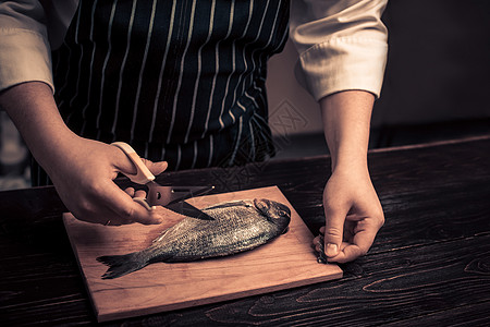 大厨在板上切鱼炊具烹饪男性食物木头屠夫厨房工人餐具营养图片