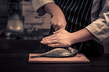 大厨在板上切鱼男人职业烤箱男性服务工作厨师工人餐厅美食图片