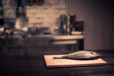 霸王鱼头木板上的新鲜鱼头胡椒厨房美食勺子种子香料木头辣椒铣削食物背景