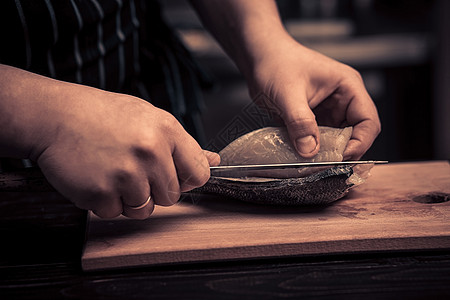 大厨在板上切鱼营养屠夫工人美食桌子木头男性炊具工具餐厅图片