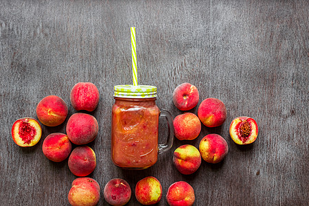 木制桌上鲜桃杯子叶子甜点花园营养食物季节冰沙果汁玻璃饮食图片