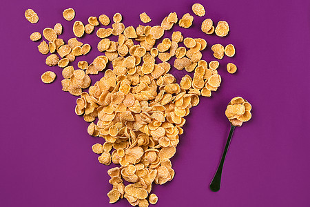 分散在紫色背景上的玉米片 复制空间静物盘子刻字营养饮食桌子美食玉米谷物早餐图片