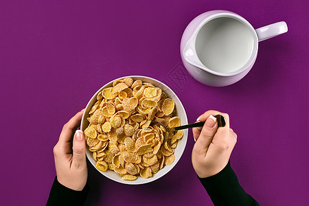 食物 健康饮食 人和饮食概念 — 紫色背景下女性早餐吃牛奶什锦早餐的特写图片