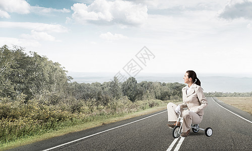 美丽的天主教女子骑着小孩的自行车员工商业骑术创造力营销女孩沥青套装踏板旅行图片
