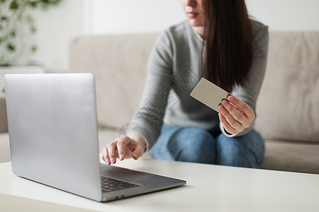 持有信用卡和在家里使用笔记本电脑的年轻妇女 在线支付 家庭购物 互联网银行业务 电子商店概念以及安全网上购物店铺钱包银行业商城电图片