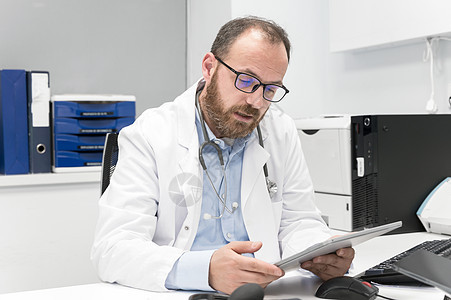 医生在工作时使用平板电脑医师职业保健工具房间诊所办公室技术触摸屏咨询图片