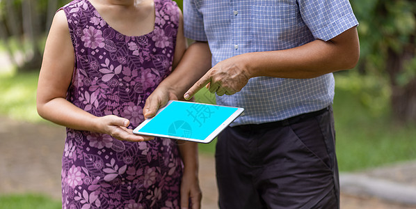 亚洲中年夫妇在后院聊天 一起看平板电脑房子幸福女性闲暇女士建筑师丈夫男性夫妻屏幕图片
