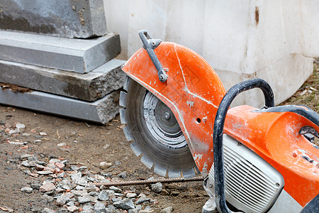 一台汽油切割机 在建筑工地和混凝土栏杆前面有一个钻石切车轮图片