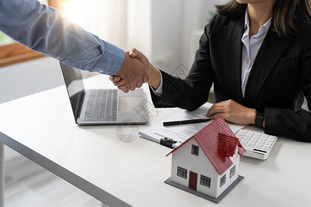 地产经纪与客户握手祝贺签约买地带保险的房子 握手好回应理念图片