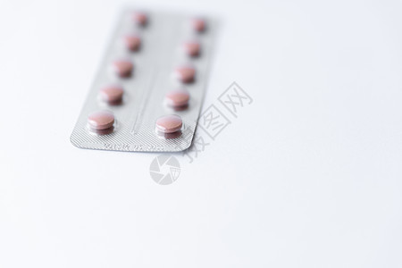药品和药丸 在白色背景特写镜头的五颜六色的药物 白色背景上有粉红色药丸的盘子 从倒置的罐子中溢出到白色表面的多色药片疼痛抗生素制图片