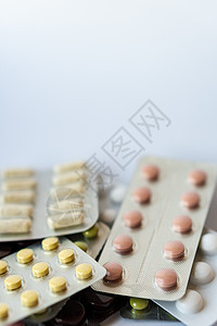 医学和药丸 在白色背景特写镜头的多色药物 白色背景上装有多色药片的盘子 从倒置的罐子中溢出到白色表面的多色药片卫生药店团体胶囊制图片