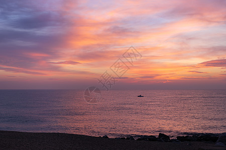 清晨粉红色的天空倒映在海面上 在日出期间航行的一个小孤独的渔夫船剪影 在海洋海岸的软的颜色日落 美好的海景图片