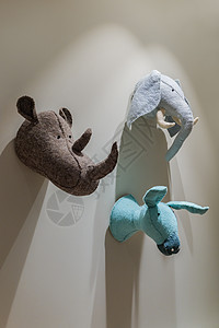 挂在墙上的轻便动物玩具 灰墙上的驴头 犀牛和大象的首饰 儿童房间里打猎留下的奖杯图片