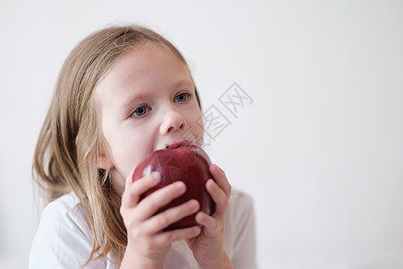 小女孩吃着心满意的新鲜红苹果图片