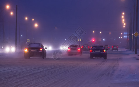 汽车沿雪覆盖的道路行驶图片