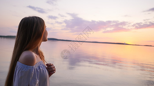 年轻女孩在海面和日落的背景女士太阳海洋运动乐趣海浪闲暇青少年生活身体图片