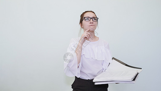 戴眼镜的女学生用笔记描绘了一个成功的女孩 一个学生描绘了一个遐想 问题的解决方案眼镜头发黑发戏服孩子文学学校学习工作室大学图片