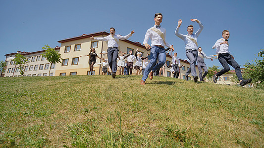俄罗斯学校的快乐毕业生从山后出现 并走向幸福 而奔向幸福文凭仪式教育木板学士证书校园成功男人女性图片