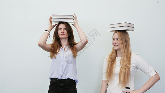 两个女学生玩的书 将他们的头套在头上图片
