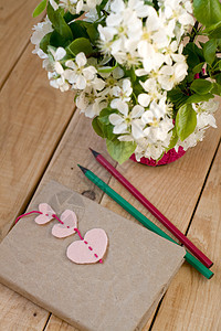一束白春花和古老的旧笔记本 书签以红心和铅笔的形式 放在未涂漆的木制背景上针织花朵礼物记录粉色惊喜毛毡白色标签图片
